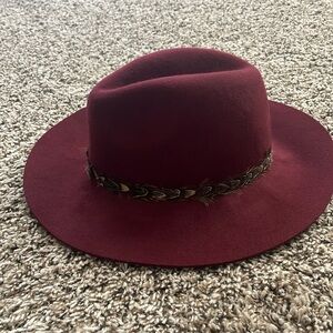 Burgundy wool hat with feather band on the rim of the hat!